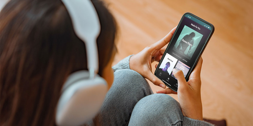Person browsing high-quality music streaming platforms on a laptop and phone