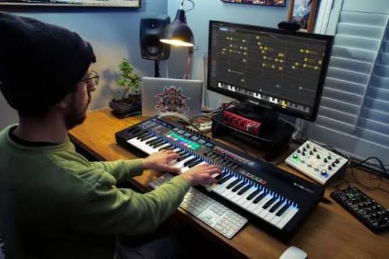 Producer working with AI music production software in a home studio